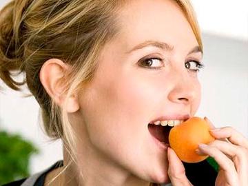 девушка кушает абрикос